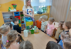 Nauczycielka omawia z dziećmi etapy sadzenia roślin