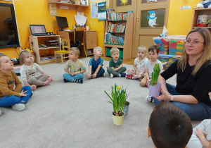 Nauczycielka ptrezentuje dzieciom rośliny i jej części
