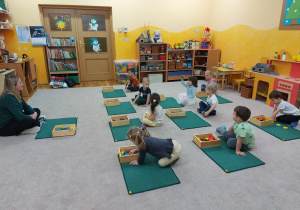 Nauczycielka omawia z dziećmi zasady korzystania z dywaników