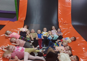 Dzieci pozując do zdjęcia leżąc na trampolinie