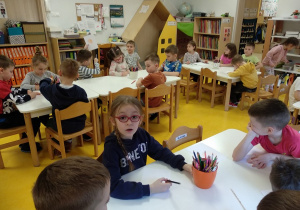 Dzieci rysują portret chłopca.