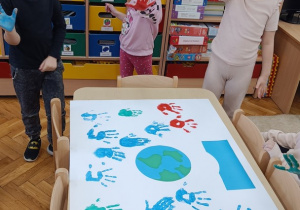 10 Dzieci pokazują dłonie zmoczone w farbie