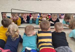 13 Przedszkolaki leżąc przed lustrem pokazują różne emocje