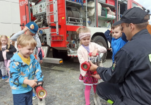 09. Dzieci sprawdzają ciężkość prądownicy strażackiej