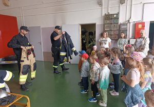 18 Dzieci oglądają ubrania strażaka