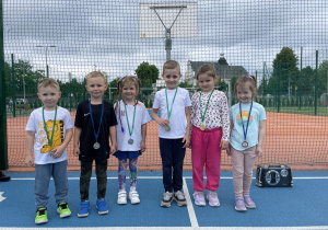 Dzieci z medalami na szyi pozują do zdjęcia