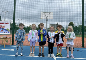 Dzieci z medalami na szyi pozują do zdjęcia