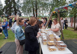 Rodzice kupują ciasta podczas festynu