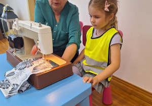 02. Pani pokazuje dziewczynce jak pracować na maszynie do szycia