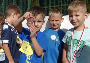 24 Chłopcy z czterolatków prezentują medale