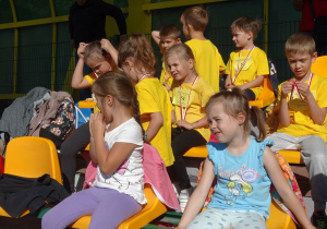 31 Dzieci z medalami siedzą na trybunach