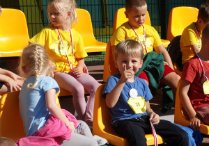 32 Dzieci z medalami siedzą na trybunach