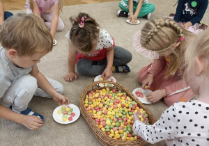 Dzieci biorą udział w konkurencji matematycznej - nakładają odpowiednią liczbę chrupek na swój talerz.