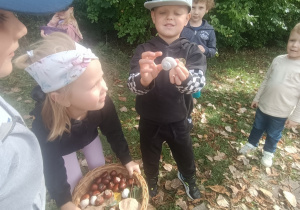 Chłopiec pokazuje znalezioną muszlę ślimaka.