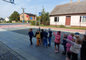 Przedszkolaki podczas spaceru omawiają znaki drogowe