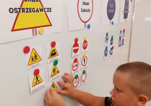 04 Chłopiec zawiesza znak