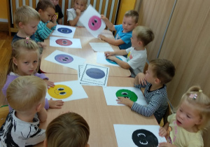 Zabawa przy stoliku z kolorowymi kropkami.