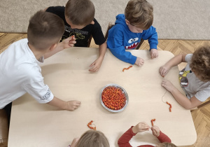 Dzieci w skupieniu pracują przy stoliczkach.