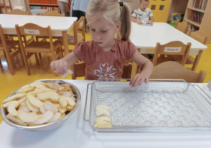 Dziewczynka układa jabłka