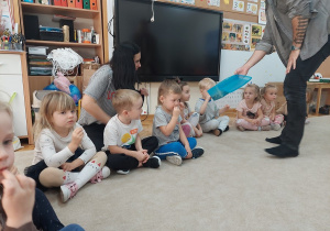 Pan Maciej częstuje dzieci suszonymi bananami.