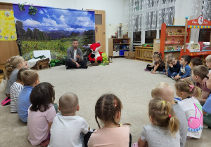 Dzieci siedzą w kole i słuchają opowieści o jeżu
