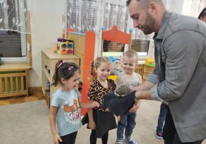 Dzieci z zainteresowaniem przyglądają się jeżowi