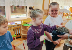Dziewczynka przygląda sie jak zachowuje się jeż