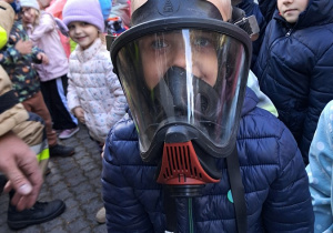 Chłopiec w masce strażackiej.