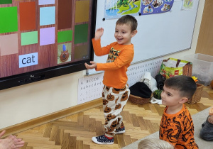 Chłopiec przy tablicy interaktywnej cieszy się ze znalezienia obrazka