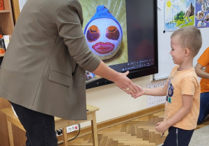 Pani dyrektor składa chłopcu gratulacje