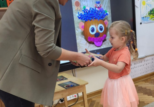 Dziewczynka odbiera nagrodę i dyplom