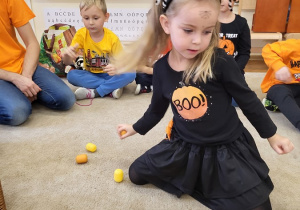Dziewczynka szuka plastikowych jajek z pestkami