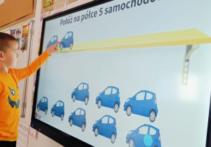 Chlopiec uklada piec smamochodow