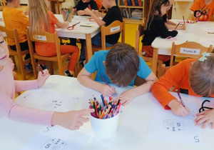 Dzieci cwicza zapis cyfry piec