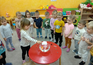 Dziewczynka sprawdza czy przemiot utonie.