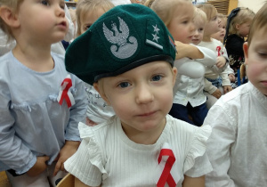 Dziewczynka w nakryciu żołnierskim.