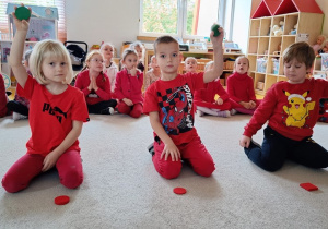 Dzieci podnosza klocki oznaczające odpowiedź tak lub nie.