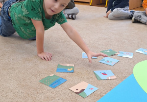 Chłopiec układa puzzle.