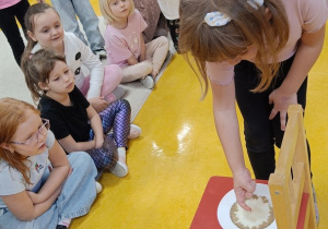 Dziewczynka wkłada palec do talerza