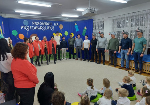 26. Mamy w czerwonych pelerynach odgrywają rolę Czerwonego Kapturka.