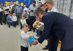 32. Pan Wójt Dariusz Michałek wręcza dzieciom upominki.
