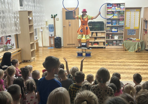 15 Artystka balansuje na desce trzymając obręcze