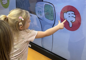 Dziewczynka wykonuje zadanie na tablicy interaktywnej