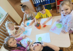 Dzieci rysują i malują na kartkach bakterie i zarazki.