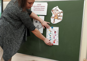Nauczycielka prezentuje dzieciom napis z emocją