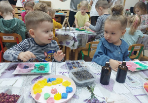 06. Dziewczynka i chłopiec wybierają suszoną rośliność do mydełek.
