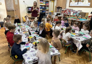 31 Dzieci siedzą przy stolikach z mydełkami