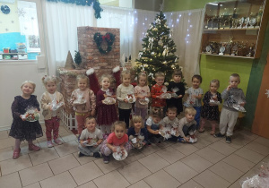 Pamiątkowe zdjęcie na tle choinki z pierniczkami.