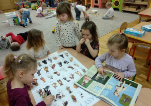 Dziewczynki oglądają albumy z pieskami - rasy psów.