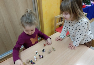 Zabawy przy stoliku z figurkami piesków.